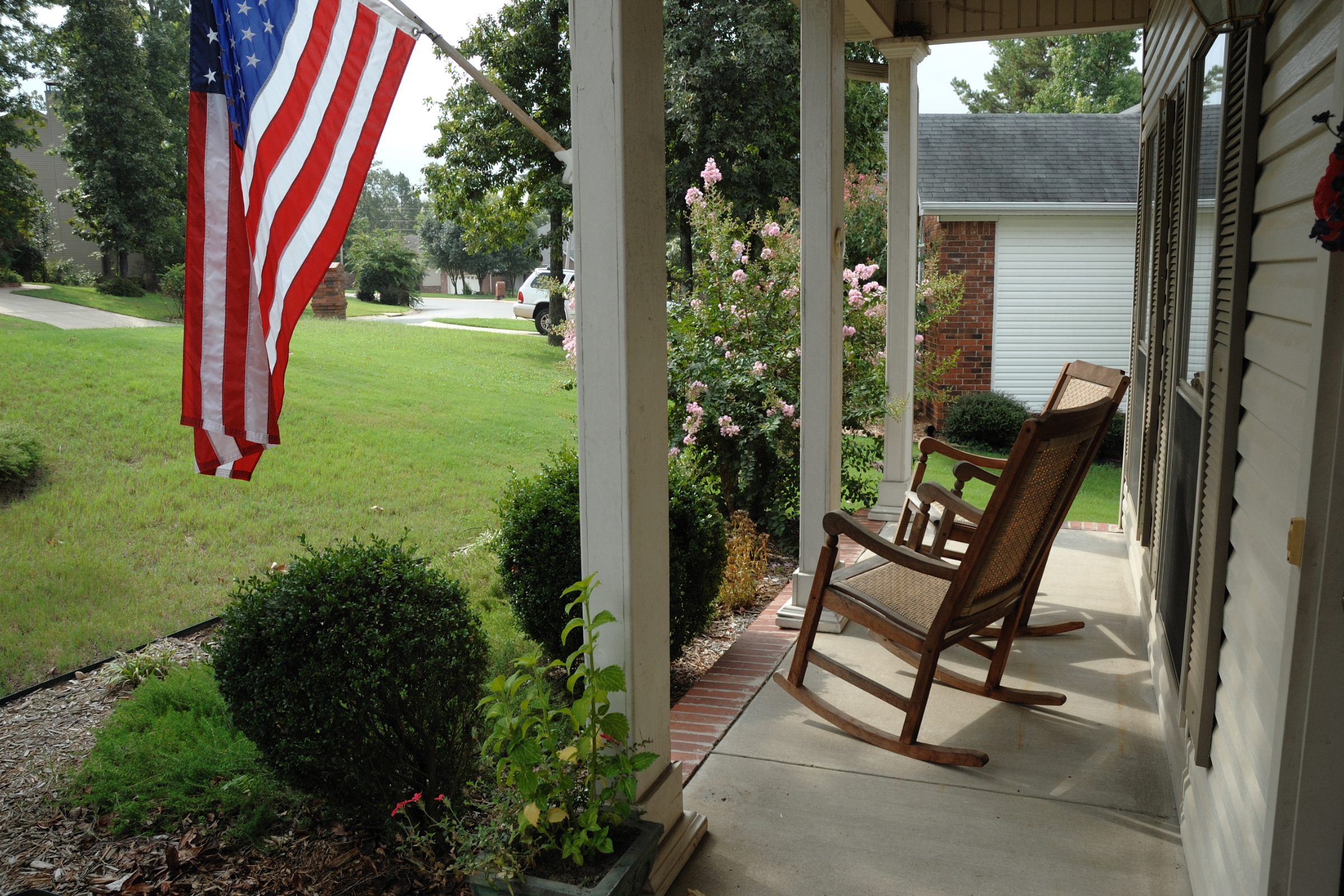chairs on the front porch with the American flag on a flag pole