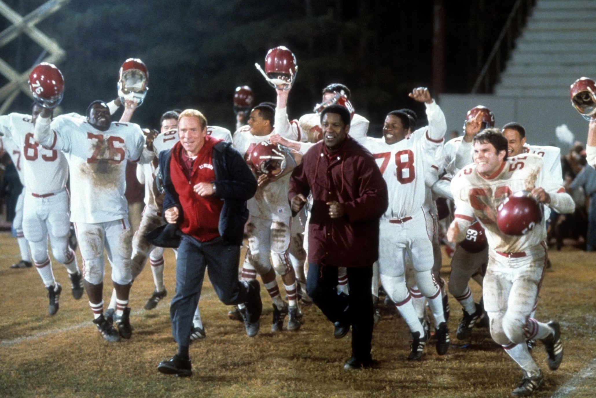 Football players and their coaches celebrating on the field