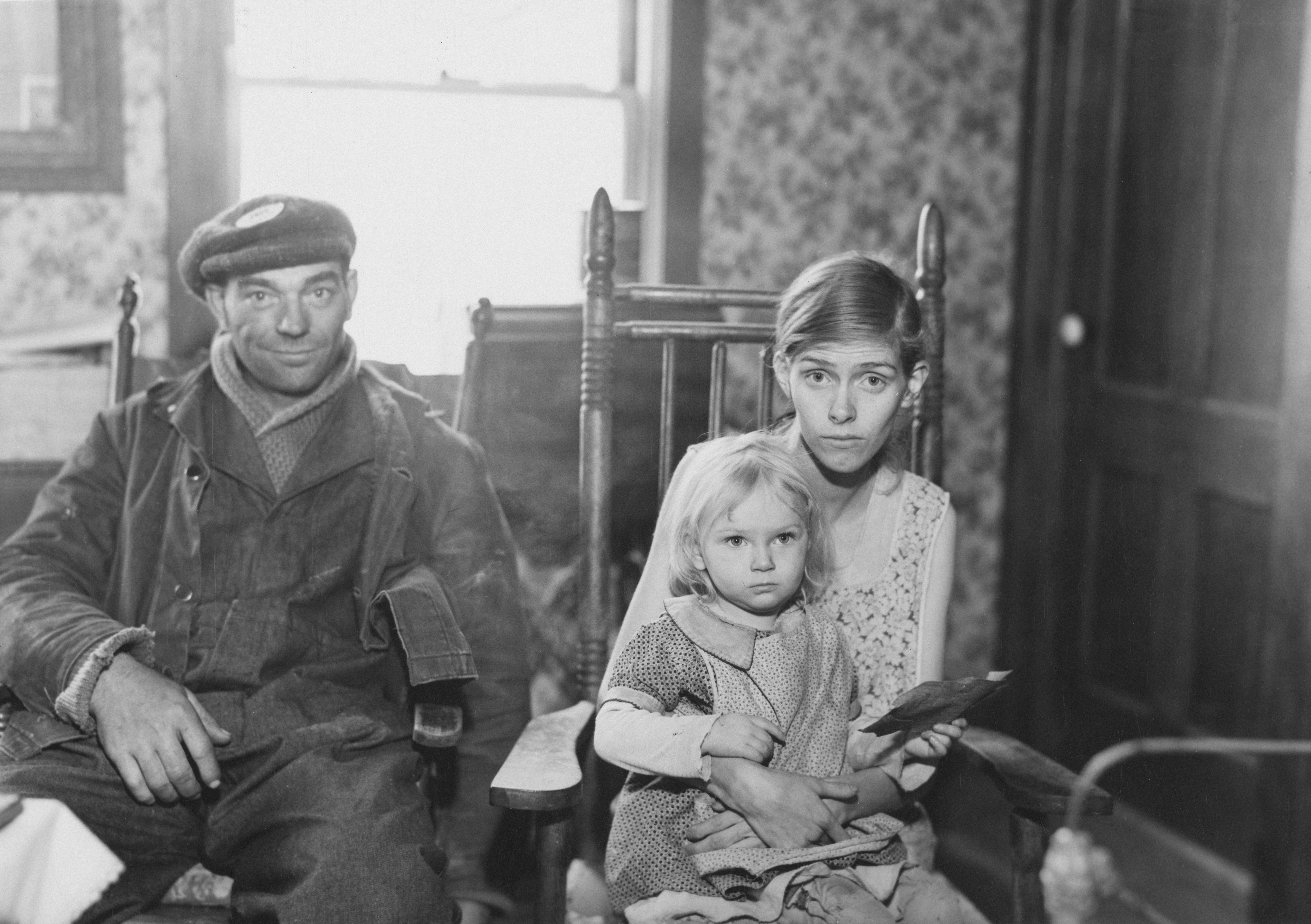 Black and white photo of a man with his wife and daughter during the 1930s